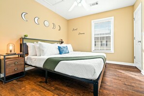 Une chambre à coucher avec un lit, une table de chevet et des éléments de décoration murale.