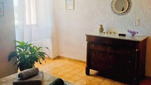A bedroom with a bed, a dresser, a mirror, a window with curtains, and a potted plant. - For nature lovers, absolute peace and quiet (Peyroules)
