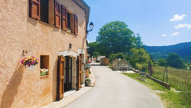 A narrow street with a building featuring wooden shutters and a hanging flower basket. - For nature lovers, absolute peace and quiet (Peyroules)