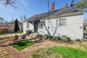 A white house with a patio, outdoor furniture, and a garden. - Crown Heights Cutie in Perfect Location! (Wichita)