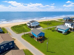 Um imóvel costeiro com vários edifícios, uma praia e uma estrada que leva ao oceano.