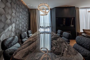 A modern conference room with a marble table, black upholstered chairs, a unique woven light fixture, and a large window with curtains. - Cube (Bar)