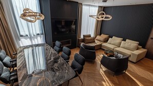 A modern living room with a marble coffee table, leather sofas, and a TV. - Cube (Bar)