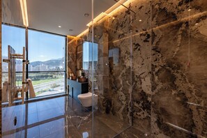 A modern bathroom with a glass shower enclosure, a toilet, and a vanity with a sink.