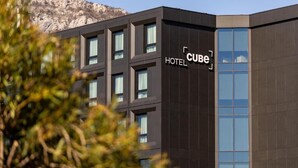 A modern hotel building with a large glass facade and a sign reading 'CUBE HOTEL.' - Cube (Bar)
