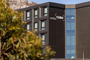 A modern hotel building with a large glass facade and a sign reading 'CUBE HOTEL.' - Cube (Bar)