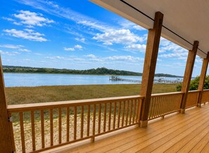 En træterrasse med udsigt over en sø og en mole.