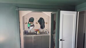 A bathroom with a mirror, sink, and toiletries. - Superb_Suburban_Summer (Herndon)