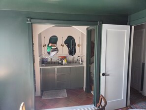 Ein Badezimmer mit Spiegel, Waschbecken und Pflegeprodukten.