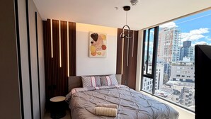 A modern bedroom with a large bed, a city view, and a minimalist design. - Vista hermosa la carolina 14th floor (Quito)
