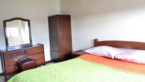 A bedroom with a bed, a dresser, a wardrobe, and a mirror. - HOTEL DEL PUENTE BOGOTA (Bogotá)