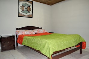 Una camera da letto con un letto, un comodino e una decorazione a parete.