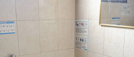 Baño con inodoro, lavamanos y cubo de basura.