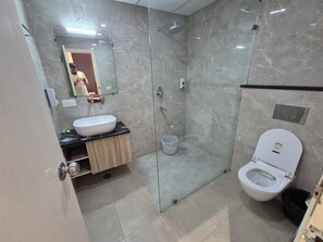 A modern bathroom with a glass-enclosed shower, a white sink, and a toilet. - OnlyStay Ginger Palace Sector 19 Noida (Noida)