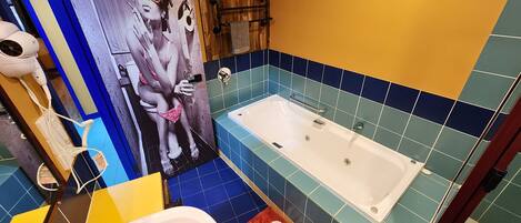 Un baño con bañera, lavamanos, espejo y toallero.