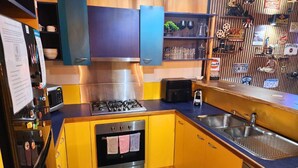 Une cuisine de taille réduite équipée d’une cuisinière à gaz, d’un four et d’un évier.