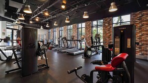Une salle de sport équipée de tapis de course, d’appareils de musculation et d’un appareil Cybex VR1.