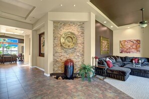 A spacious living area with a fireplace, a large vase, and a sofa. - Spacious 4-bedroom house with Golf Course view in marvelous Bermuda Dunes. (Bermuda Dunes)