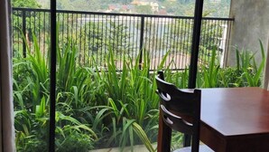 Un balcón con vistas a un paisaje verde exuberante y un edificio distante.