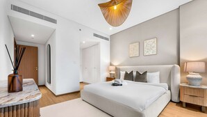 A modern bedroom with a large bed, bedside tables, a wooden side table, and a hanging light fixture. - Free Housekeeping Visits During Your Stay - Stayshort - Bright 2 Bedroom in Madinat Jumeirah Living That Sleeps 6 With Balcony (Dubai)