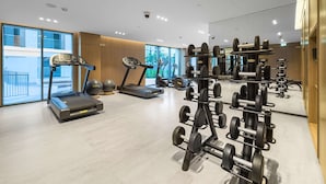 A modern gym with treadmills, elliptical machines, and weightlifting equipment. - Free Housekeeping Visits During Your Stay - Stayshort - Bright 2 Bedroom in Madinat Jumeirah Living That Sleeps 6 With Balcony (Dubai)