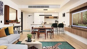 A modern living room with a sofa, coffee table, and a dining area with chairs and a table. - The Brass Banana in Petersham (Sydney)