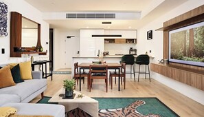A modern living room with a sofa, coffee table, and a dining area with chairs and a table. - The Brass Banana in Petersham (Sydney)