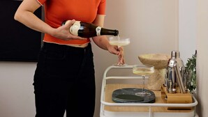 Une personne qui verse une boisson dans un verre.