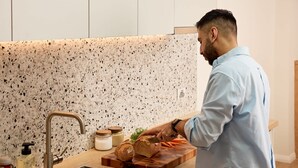 Cucina con schienale in granito, lavello in acciaio inossidabile e piano di lavoro in legno.