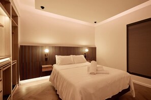 A hotel room with a bed, bedside tables, a wooden headboard, and a window with blinds. - The Brass Room - Flamingo on Oxford Street (Sydney)