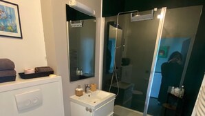 Un bagno moderno con WC, lavandino e doccia.