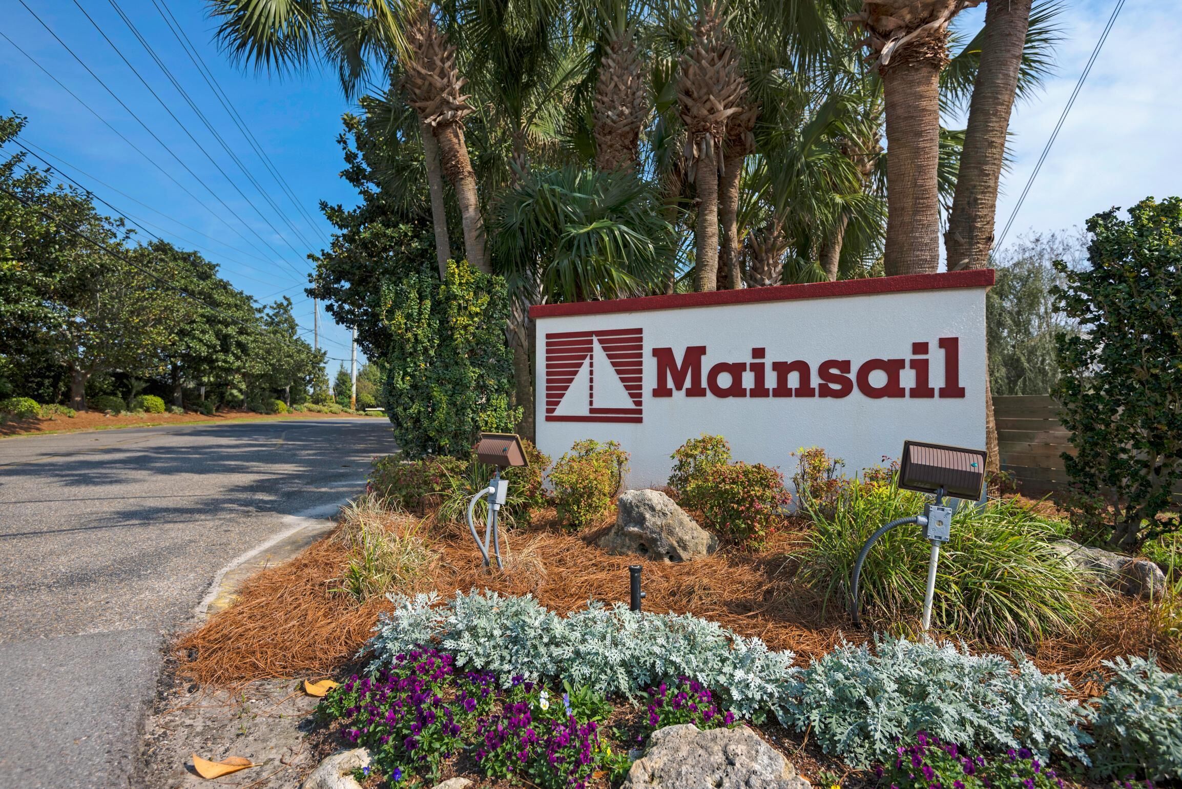 A sign for Mainsail with a solar-powered street light and landscaped garden.