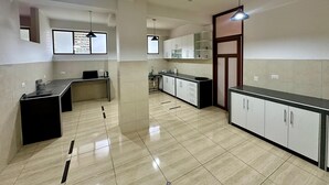A modern kitchen with a central island, pendant lighting, and a view of the adjacent living area. - Casa Ymelda Desaguadero (Desaguadero)