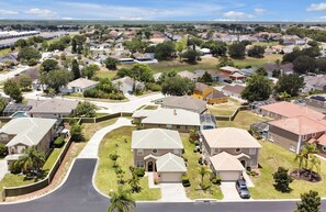 A residential area with houses, roads, and greenery. - Happy Planet 1: Private Pool and Spa! BBQ Grill. (Davenport)