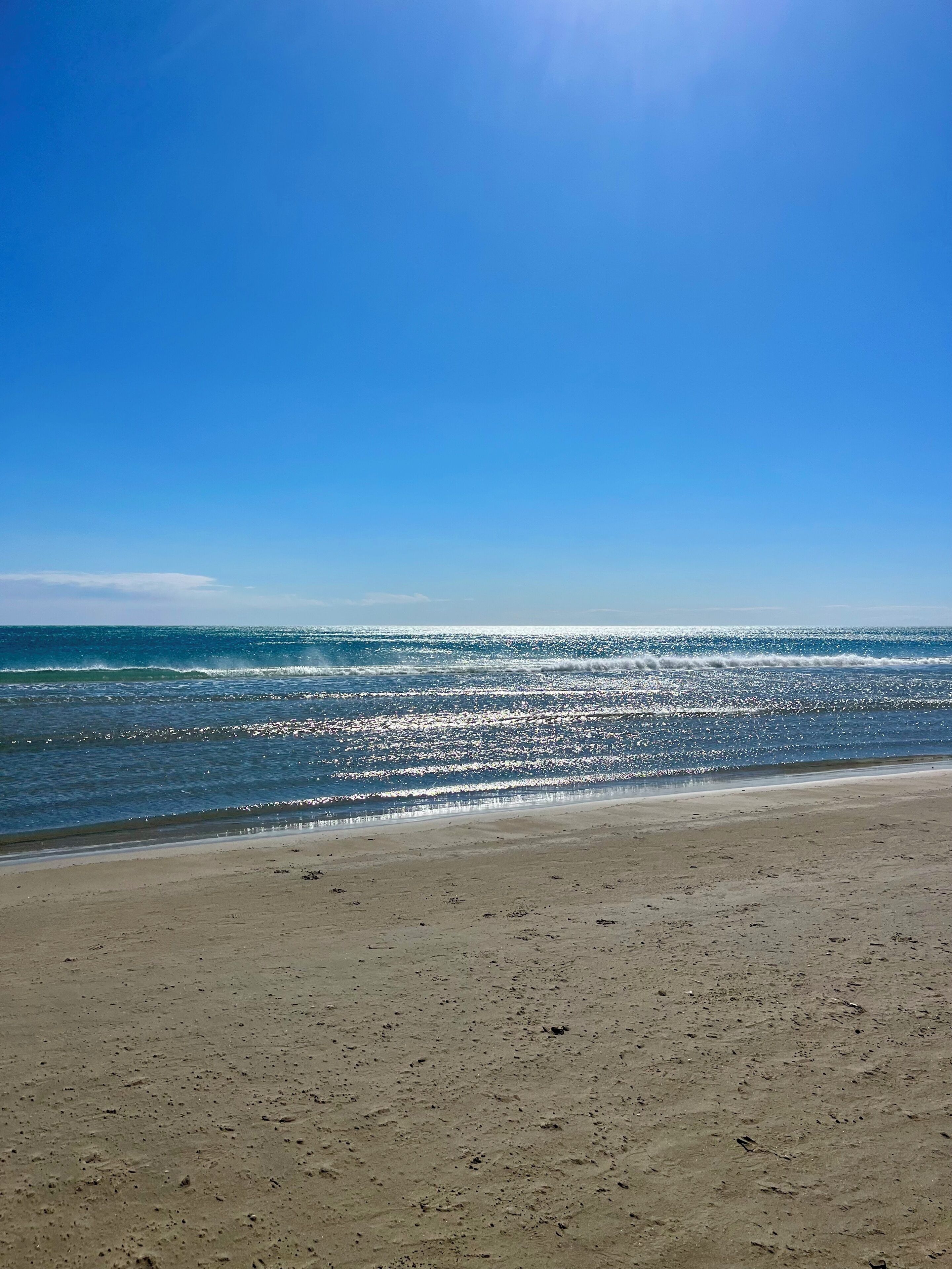 A beach with a clear sky and calm sea.. T1 beach with secure parking space