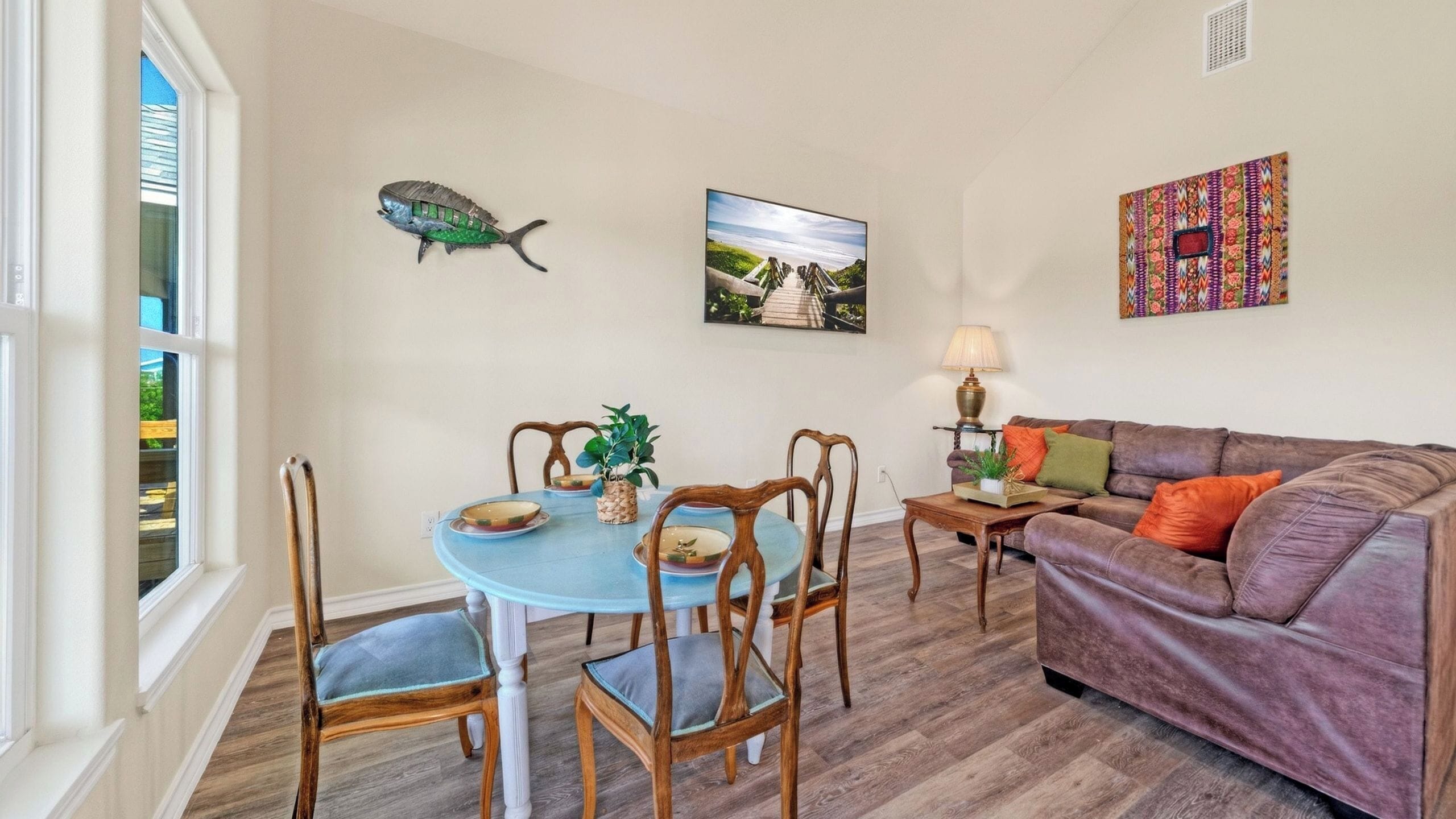 Un comedor con una mesa redonda, sillas y una decoración de pez en la pared.