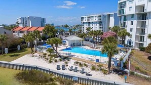 Et resort med swimmingpool, palmer og moderne bygninger.