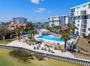 Ein Resort mit Schwimmbad, Palmen und modernen Gebäuden.