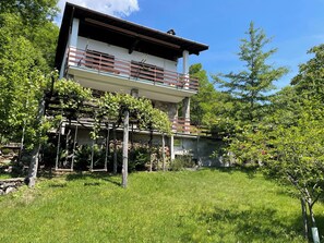 A two-story building with a balcony, surrounded by greenery and trees. - Il Cervo by Interhome (Gera Lario)