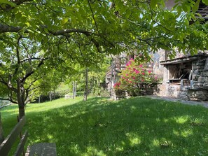 Ein Gebäude aus Stein mit einer Steintreppe, umgeben von üppigem Grün und Bäumen.