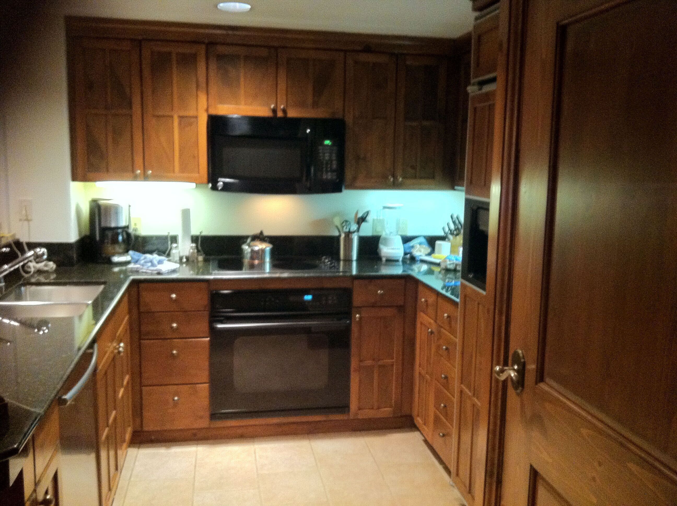 A kitchen with wooden cabinets, a microwave, a coffee maker, and a dishwasher.