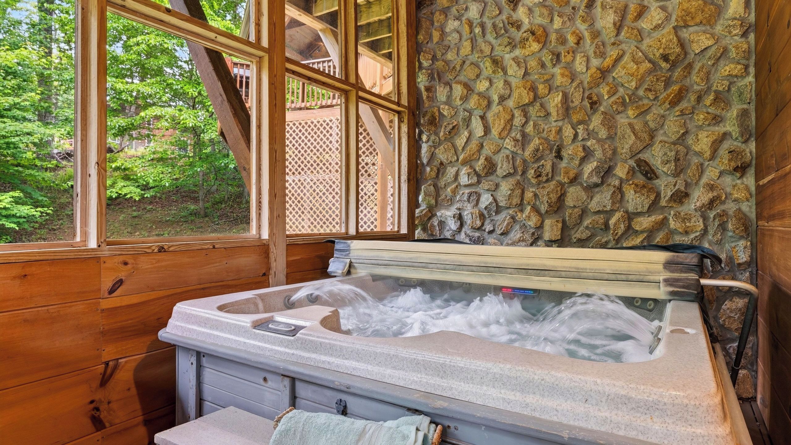 A stone wall, wooden cabin interior, and a hot tub.