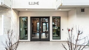A building with the name 'ILLUME' above the entrance, featuring a glass door and a visible number '920' on the right. - Walkable Gulch Condo- Sleeps 8- Gorgeous Pool (Nashville)