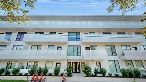 A modern multi-story building with a flat facade, large windows, and a central entrance. - Walkable Gulch Condo- Sleeps 8- Gorgeous Pool (Nashville)