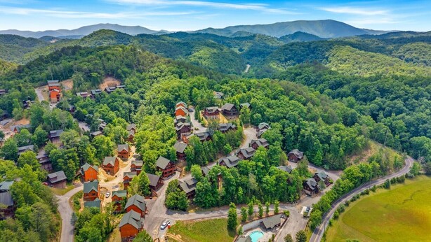 A residential area with multiple houses, roads, and a swimming pool. - Smokies Luxe View: Hot Tub, Fireplaces, Games+MORE (Pigeon Forge)