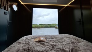 Een kamer met een bed, een raam en uitzicht op de omgeving.