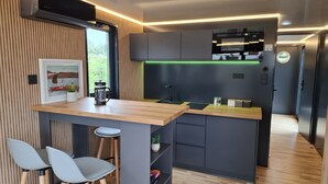 Een moderne keuken met een houten kookeiland, barkrukken en uitzicht op de omgeving.