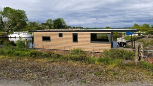 Een modern, gelijkvloers gebouw met een plat dak, grote ramen en een houten gevel.