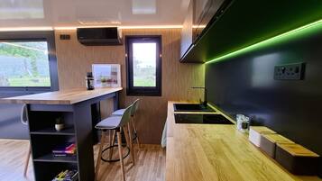 Una cocina moderna con encimera de madera, electrodomésticos integrados y vistas a zonas verdes.