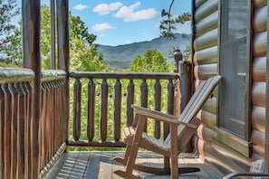A wooden rocking chair on a porch with a view of mountains. - Adohi Lodge | Panoramic Views off the Deck! (Sevierville)